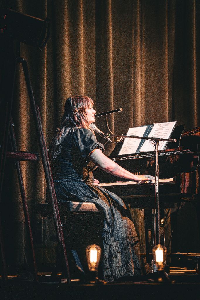 Amanda Grace performing at the piano on stage