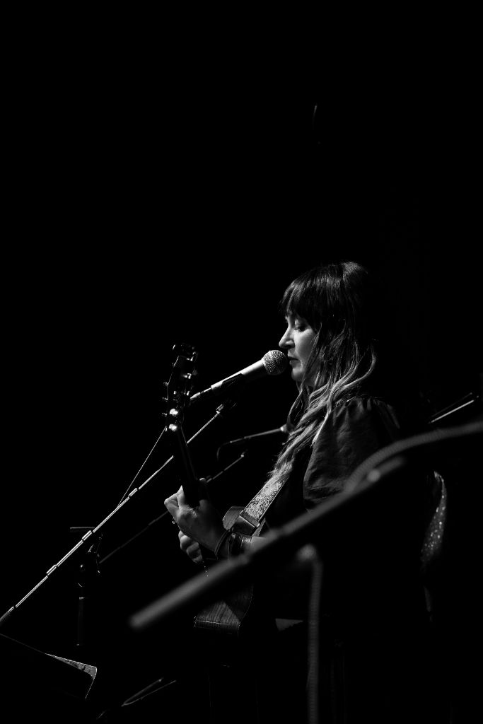 Amanda Grace performing on stage in black and white